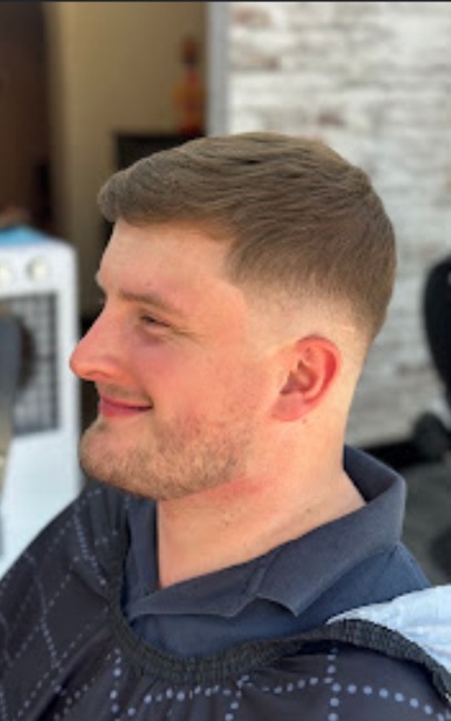 Client with a tapered scissor cut and clean neckline, side profile