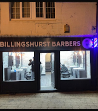 The Billingshurst Barbers shopfront on the High Street lit up at night