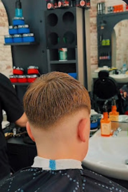 Textured crop with a low skin fade, photographed from behind in the shop