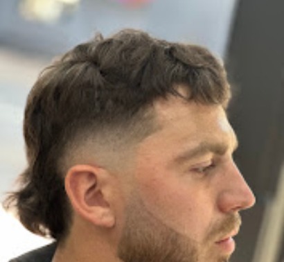 Modern mullet with faded sides and a natural curly top