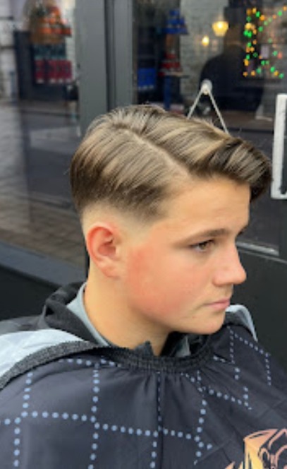Swept-back pompadour finished with a soft taper fade